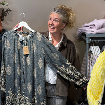 Helene Elmer fra Pure Copenhagen viser en Marta kjole frem i butikken i Tune